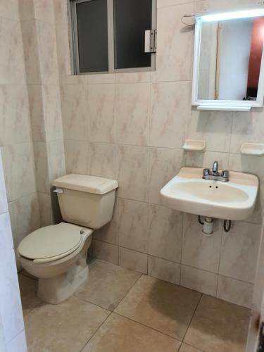 y baño con aseo y lavamanos. en Hotel Atlantico a 150 mts de Playa Martí, en Veracruz