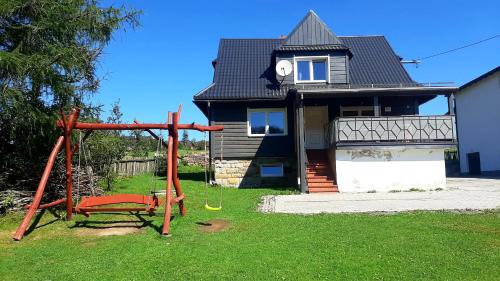 a house with a swing in front of it at Domek na Zagroniu in Istebna