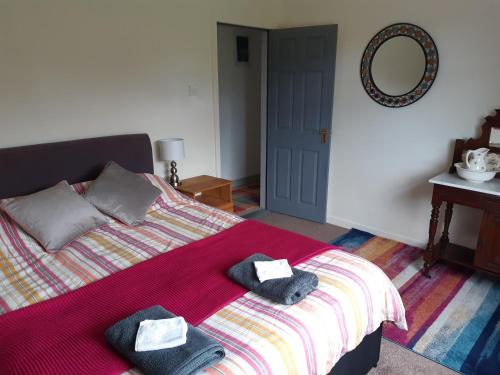 a bedroom with a bed with two towels on it at Peggys Escape in Ballycastle