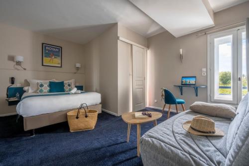 une chambre d'hôtel avec un lit et un canapé dans l'établissement Un Hotel sur le Port, à La Rochelle