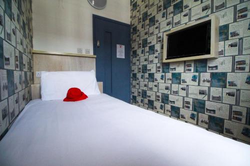 a bedroom with a white bed with a red hat on it at London Backpackers Youth Hostel 18 - 35 Years Old Only in London