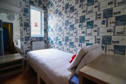 a bedroom with a bed and a wall of pictures at London Backpackers Youth Hostel 18 - 35 Years Old Only in London