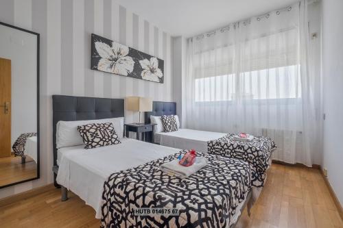 a bedroom with two beds and a couch and a window at Alcam Vila Olímpica in Barcelona