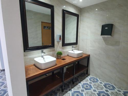 a bathroom with two sinks and two mirrors at Hotel Jar8 Acuario enfrente al Acuario de Veracruz in Veracruz
