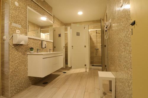 uma casa de banho com um lavatório e um chuveiro em Águeda Hostel & Friends em Águeda