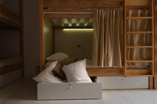 a bunk bed with a white couch in a room at Águeda Hostel & Friends in Águeda