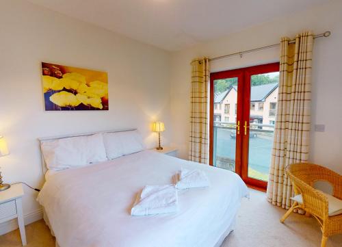 een slaapkamer met een groot wit bed en een raam bij Lakeside Holiday Homes in Killaloe