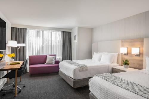 a hotel room with two beds and a purple chair at Crowne Plaza Hotel Atlanta Perimeter at Ravinia, an IHG Hotel in Atlanta