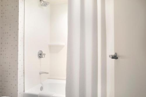 a bathroom with a shower with a shower curtain at Crowne Plaza Atlanta Perimeter at Ravinia by IHG in Atlanta