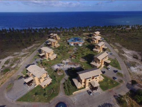 an aerial view of a large house by the ocean at Apt Coral Azul Iberostate Praia do Forte in Praia do Forte