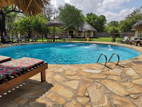 ein Pool in einem Garten mit einer Bank davor in der Unterkunft Africa Safari Selous Nyerere national park in Nyakisiku