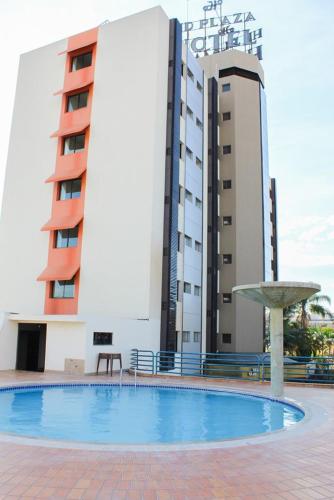 a large swimming pool in front of a building at HD Plaza Hotel in Assis