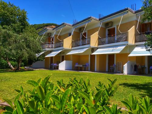 a building with a lawn in front of it at Artolithia Apartments in Rizá