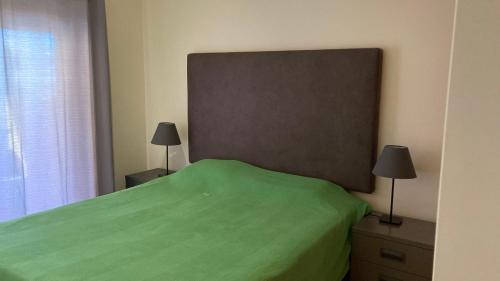 1 dormitorio con 1 cama verde y 2 lámparas en Franciscos em Cabanas Golf en Conceição