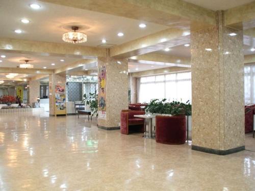 eine Lobby mit einer großen Lobby mit Tischen und Stühlen in der Unterkunft Kochi - Hotel - Vacation STAY 92256 in Kōchi