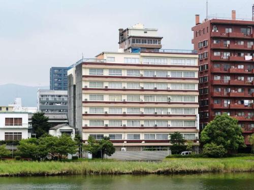 ein großes Apartmenthaus neben einem Wasserkörper in der Unterkunft Kochi - Hotel - Vacation STAY 92256 in Kōchi