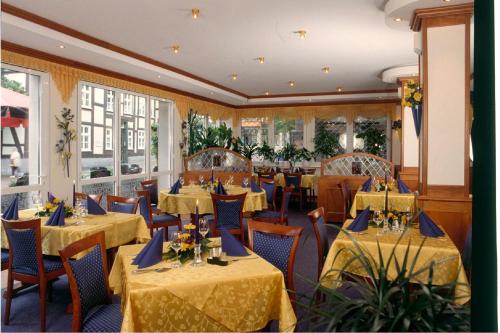 ein Restaurant mit Tischen und Stühlen mit gelbem Tischtuch in der Unterkunft Zum Alten Brauhaus in Hofgeismar
