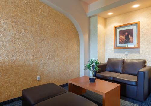 a waiting room with a couch and a table at Hotel Flamingo Inn in Querétaro