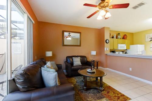 a living room with a couch and a ceiling fan at Paradise Palms in Kissimmee