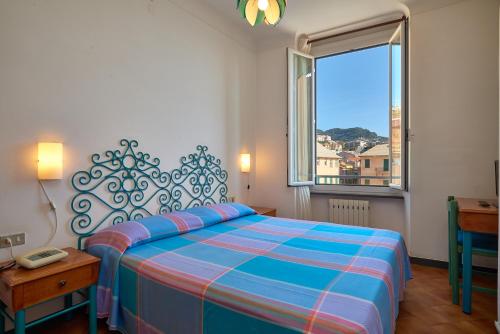 a bedroom with a large bed and a window at Hotel Garibaldi in Finale Ligure