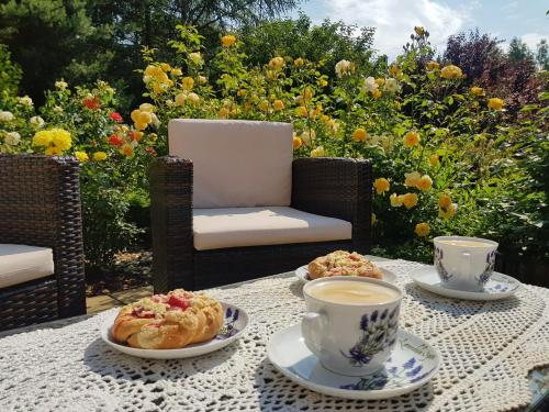 a table with two cups of coffee and pastries on it at Zielono Mi - Dom Gościnny w Łapalicach in Łapalice