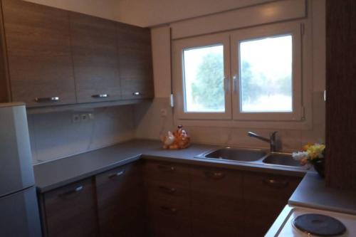 a kitchen with a sink and a window at Alykes Volos in Volos