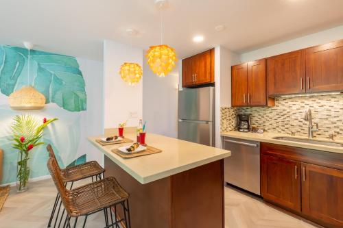 a kitchen with wooden cabinets and a island with stools at Modern, Romantic Vibes in the Tropics in Kahuku