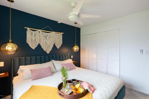 a bedroom with a bed with a tray of food on it at Modern, Romantic Vibes in the Tropics in Kahuku