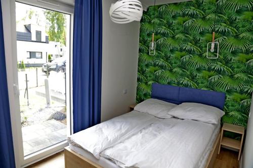 a bedroom with a bed with a green wall at Chill&Sun Yellow in Łukęcin