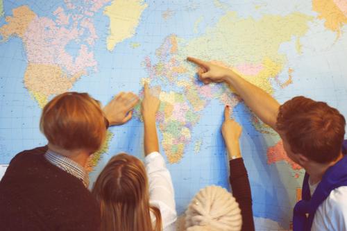 a group of people pointing to a world map at 16eur - Old Town Munkenhof in Tallinn