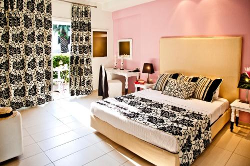 a bedroom with a bed and a room with a table at Mandraki Village Boutique Hotel in Koukounaries