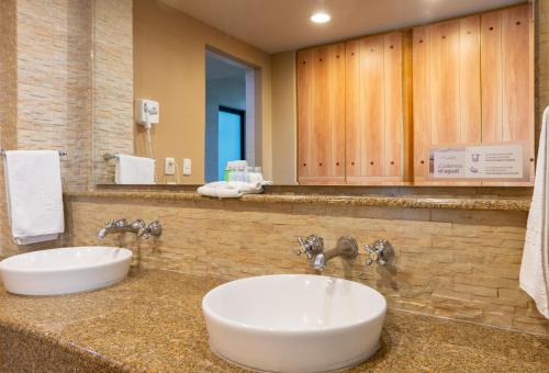 a bathroom with a sink and a large mirror at Hotel Flamingo Inn in Querétaro