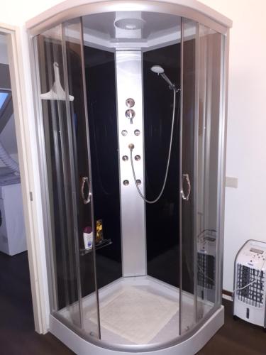 a shower in a room with a glass enclosure at Studio vlak bij het strand in Petten
