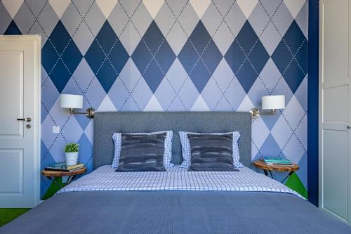 1 dormitorio azul con 1 cama con 2 almohadas en The Golfer Apartment with Jacuzzi, en Cluj-Napoca