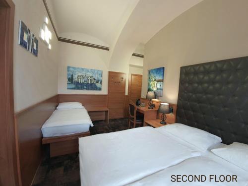 a hotel room with two beds and a desk at Center Ljubljana in Ljubljana