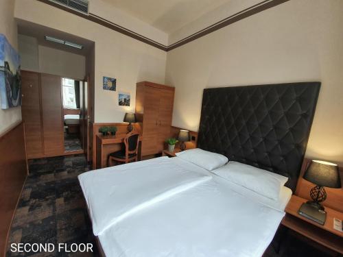 a bedroom with a large bed with a black headboard at Center Ljubljana in Ljubljana