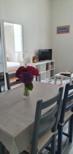 tavolo da pranzo con vaso di fiori viola di Escale dinannaise a Dinan