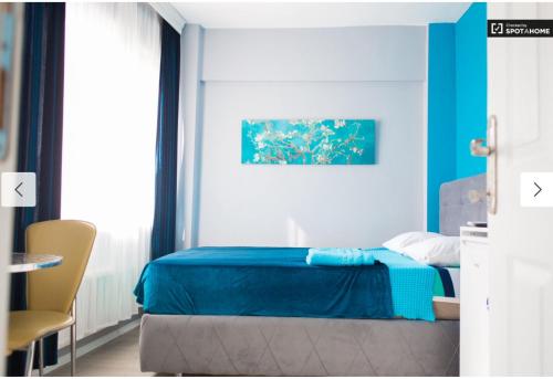 - une chambre avec un lit bleu et une chaise dans l'établissement Blue Apartments, à Istanbul