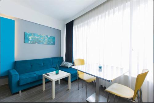 - un salon avec un canapé bleu et une table dans l'établissement Blue Apartments, à Istanbul