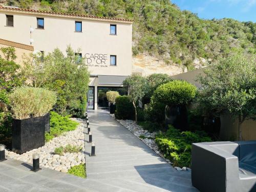 a building with a sidewalk in front of a building at Hotel Centre Nautique in Bonifacio