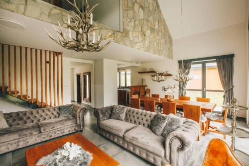 ein Wohnzimmer mit Sofas und ein Esszimmer in der Unterkunft Woodpark Slovianka in Valča