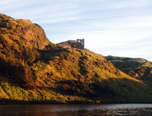 a castle on a hill next to a body of water at voco Edinburgh - Royal Terrace by IHG in Edinburgh