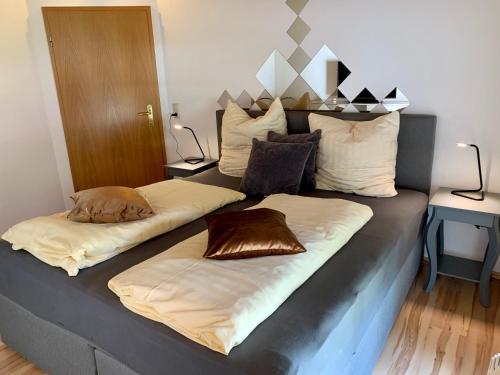 a bed with two pillows on top of it at Apartment "Im Sonneneck" bis 4 Personen mit Parkplatz, W-LAN, Netflix im Thüringer Wald, Schleusingen in Schleusingen