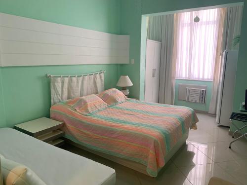 a bedroom with a large bed and a window at Studio Copacabana 1003 in Rio de Janeiro