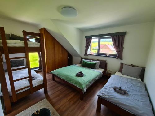 sypialnia z 2 łóżkami piętrowymi i oknem w obiekcie Woodpark Valčianska dolina w mieście Valča