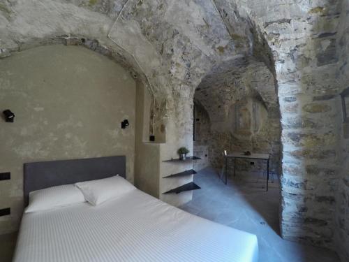 een slaapkamer met een bed in een stenen muur bij La Casa Giusta - Domus Ista in Cipressa