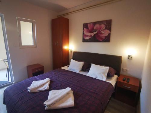 ein Schlafzimmer mit einem Bett mit zwei Handtüchern darauf in der Unterkunft Radović Apartments in Budva