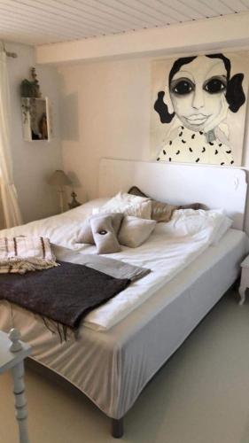 a bedroom with a bed with a painting of a woman at Tina Risager bed & breakfast in Sindal