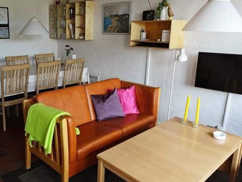 ein Wohnzimmer mit einem Sofa und einem Tisch in der Unterkunft 6 person holiday home in Bl vand in Blåvand