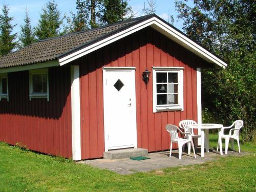 a red shed with a table and chairs in it at 6 person holiday home in HÅCKSVIK-By Traum in Håcksvik